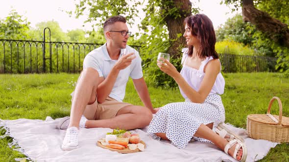 Happy Couple Having Picnic at Summer Park