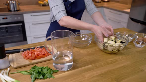 Girl Soaks Chopped Eggplant in Salt Water Before Cooking