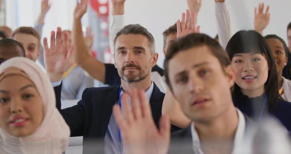 Audience at a seminar raising hands to ask questions