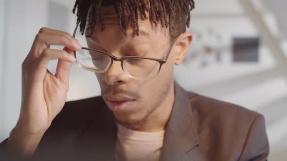 Tired Afro-American Man Working on Laptop in Office