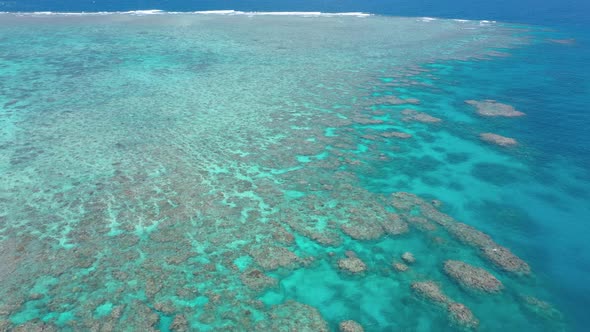 Great Barrier Reef backward aerial of coral ecosystem and colorful water, near Cairns, Queensland, A