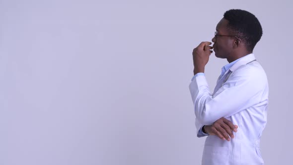 Profile View of Young Happy African Man Doctor Thinking