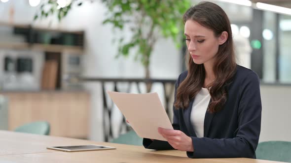 Professional Businesswoman Reading Documents at Work 