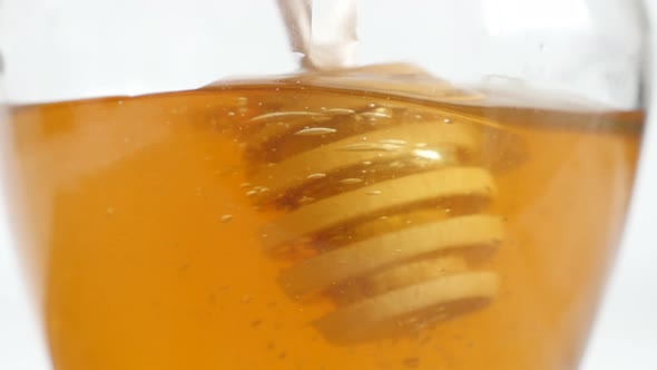 Spiral honey dipper used in jar close-up 4K 2160p 30fps UltraHD footage - Wooden utensil dipped in s