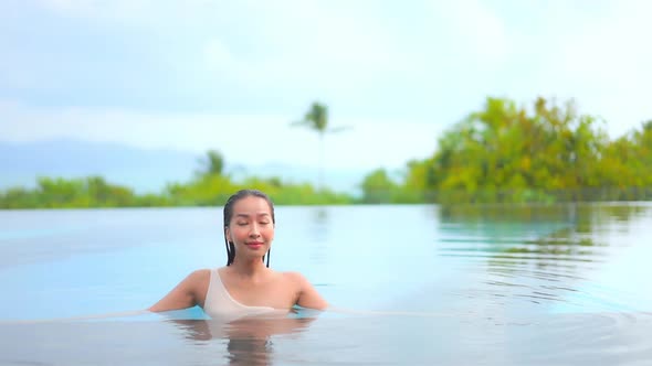 Young asian woman enjoy around outdoor swimming pool for leisure