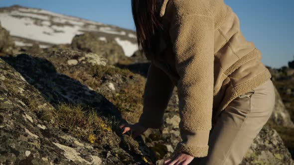 Video of a Girl in a Beige Jacket and Hiking Beige Boots Climbs Up the Mountain