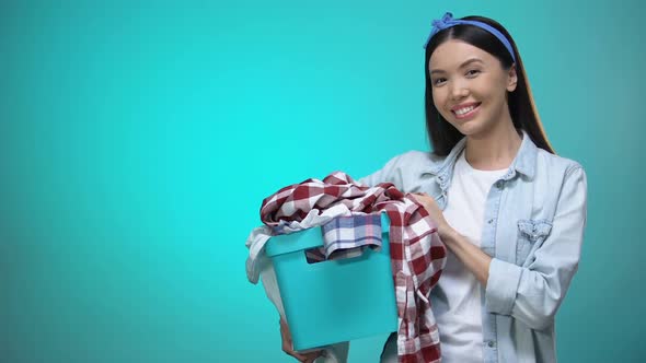 Cheerful Woman Holding Laundry Basket and Smiling at Camera Template for Text