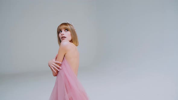 Woman in pink. A young caucasian woman with bob hair posing in a pink airy dress 