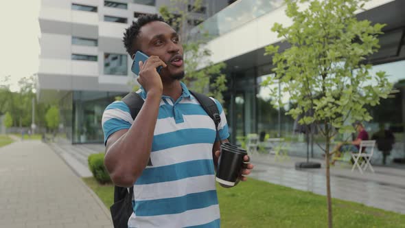 Portrait of African American Man in Casual Clothes in City Talking on Smart Phone