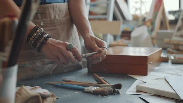 Female Artist Choosing and Taking Paintbrush