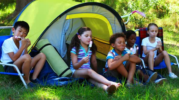 Kids having marshmallows outside tent