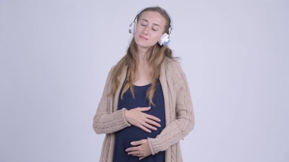 Young Beautiful Pregnant Woman Listening To Music