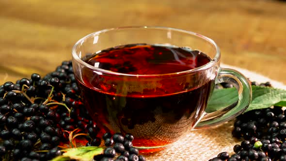 Close Up Natural Red Berry Tea In A Glass Cup On A Turntable. Berry Tea From Black Elderberry.