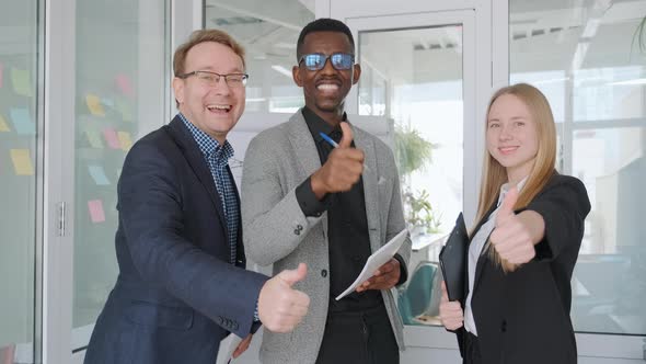 Business Partners in Office Stand Together and Show Thumbs Up Happy Emotions
