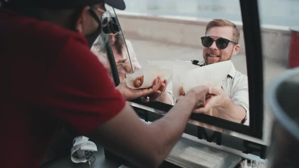 Young People Buying Hot Dogs from Food Trailer