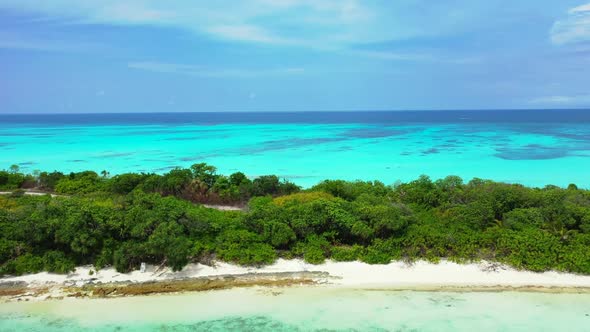 Aerial scenery of relaxing bay beach break by blue ocean and white sandy background of a dayout afte