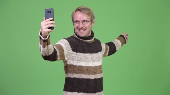 Studio Shot of Happy Handsome Man Video Calling with Phone