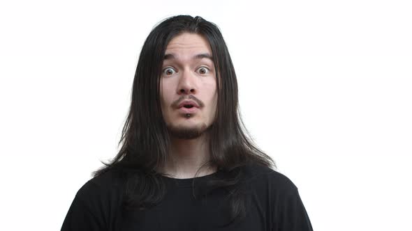 Closeup of Handsome Asian Guy with Moustache and Long Dark Hair Rocker Hairstyle Looking Amazed and