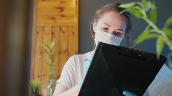 Young Student Teenager Girl in Protective Mask Standing Near Window on Home Self Isolation