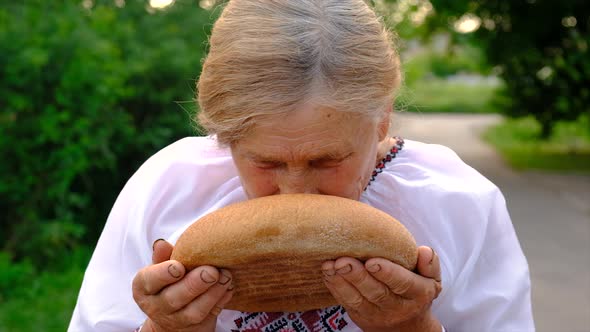 Grandmother with Ukrainian Bread in Her Hands