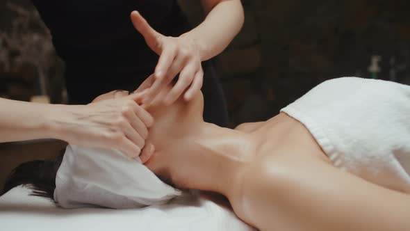 Woman Receiving Facial Massage in Spa Lying on Massage Table. Skin Care, Face Treatment