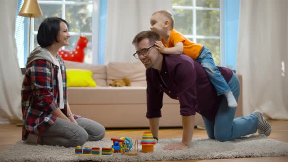 Father, Mother and Son Playing on the Floor in Living Room.