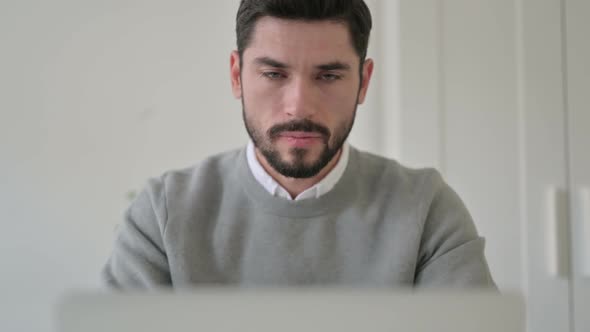 Close Up of Man Showing Thumbs Down While Using Laptop