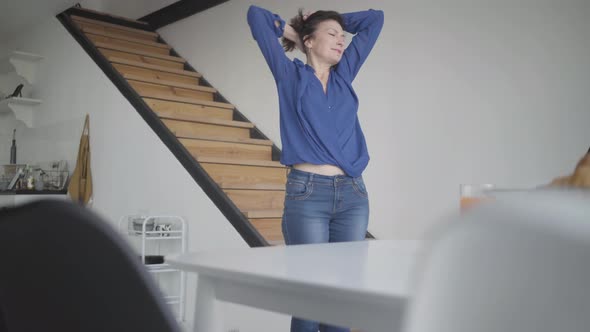 Happy Beautiful Caucasian Woman Stretching in the Morning at Home. Portrait of Elegant Brunette