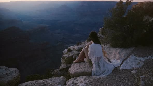 Slow Motion Cinematic Shot of Excited Young Woman with Hair Blowing in the Wind Sitting