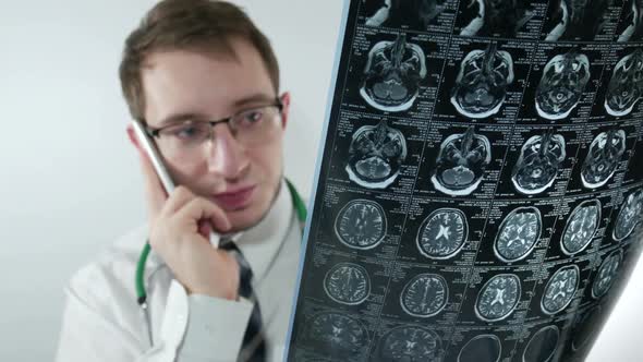 Angry Doctor Examines An X Ray And Talking On The Phone