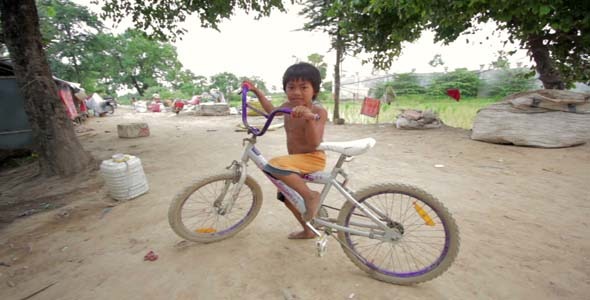 Cambodian Boy In Slum, Shacks in Background