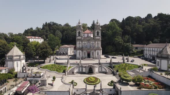 Aerial pullback reveal Majestic Bom Jesus church and Iconic stairs with gardens - Braga