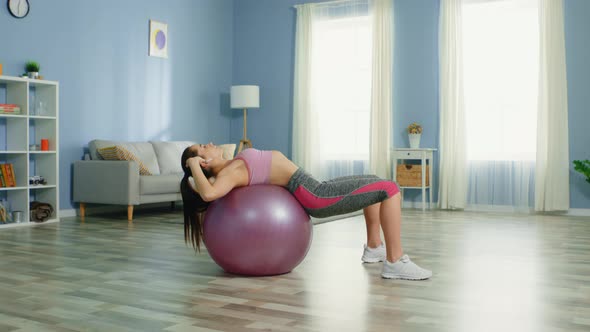 Young Pretty Woman Is Doing Crunches on Fitness Ball