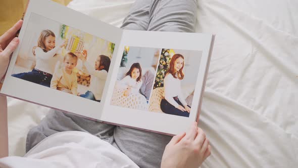 Hands Scroll Through Pages of Photobook