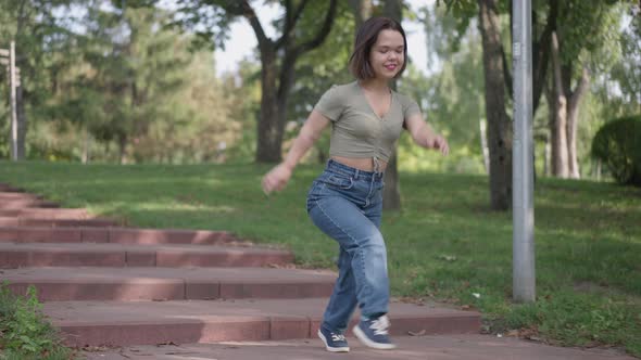 Carefree Laughing Little Woman Running Downstairs in Summer Park Laughing Out Loud