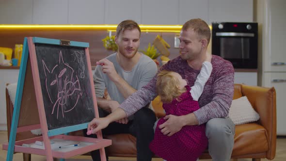 Lgbt Parents with Child Drawing on Blackboard
