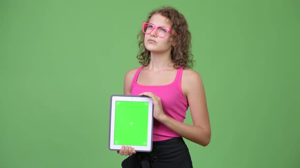 Young Happy Beautiful Nerd Woman Thinking While Showing Digital Tablet