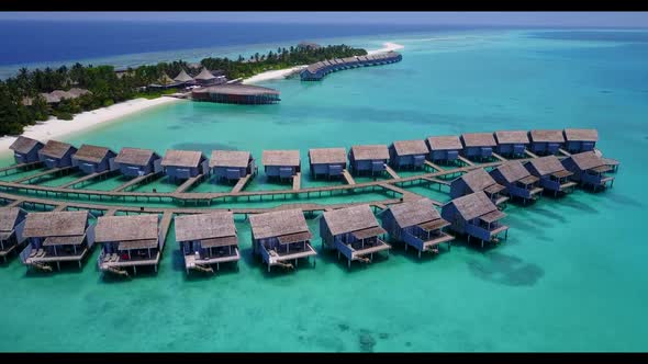 Aerial top down seascape of marine resort beach wildlife by turquoise lagoon with white sand backgro