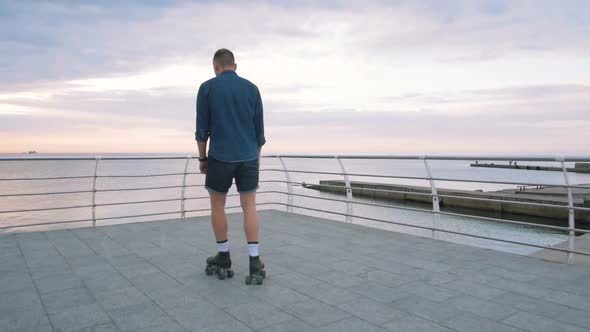 a Young Caucasian Man Roller Skating with Quad Skates Near the Sea Slow Motion