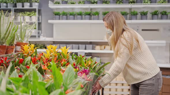 Woman in a Protective Mask Chooses an Exotic Flower in a Flower Shop