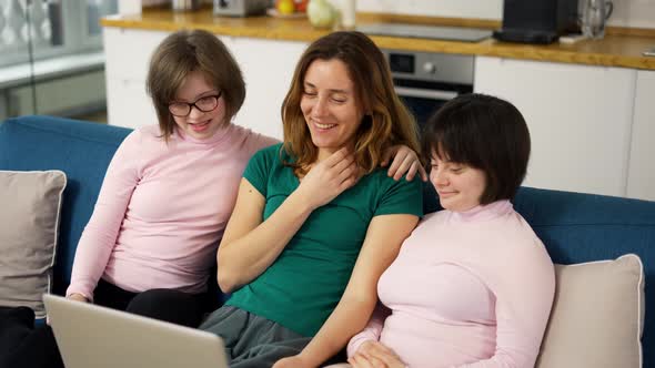 Mother with Two Daughters Down Syndrome Making Video Call Using Laptop