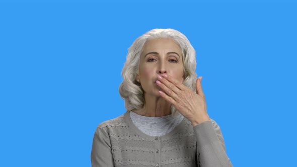 Woman Sending Air Kiss on Color Background