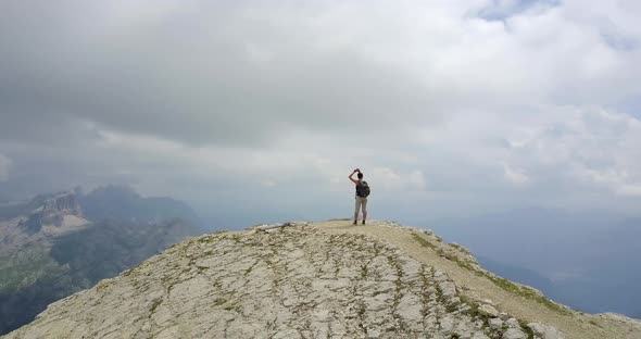 Aerial drone view of a woman hiking in the mountains.