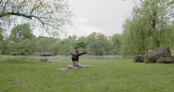 Fit Woman Doing Morning Yoga Exercises in the Park