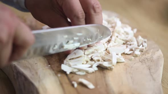 Chief finely cuts the champignons on the board