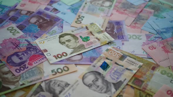 Ukrainian hryvnia money is spinning on the table. Many hryvnia currency banknotes