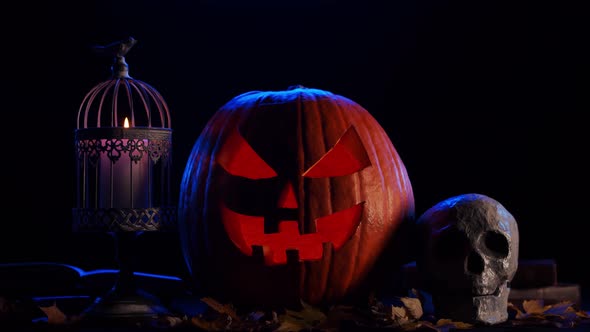 Scary laughing pumpkin and an old skull over the frightening gothic background.