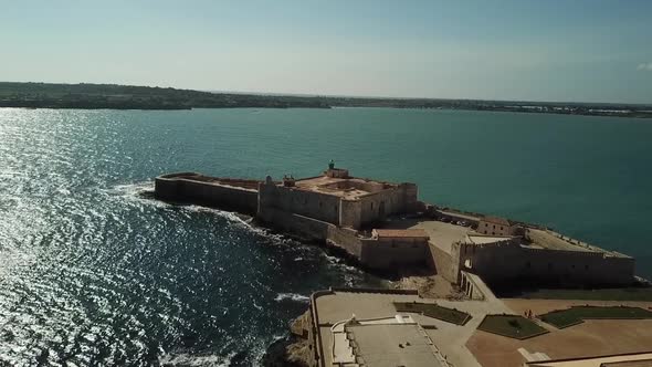 Drone flight towards the Castello Maniace on the Ortigya island, Syracuse, Sicily, Italy.