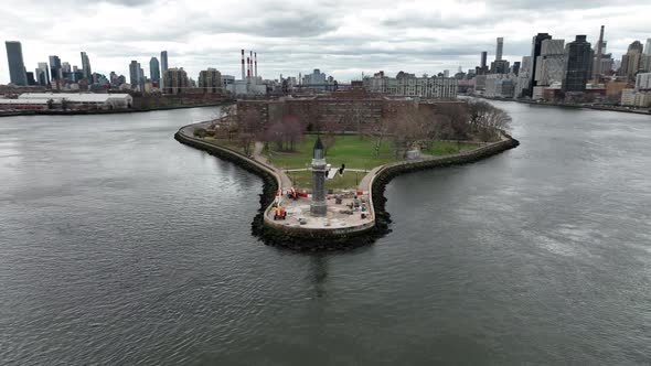 An aerial view of the Roosevelt Island lighthouse on a cloudy day. The camera truck left, pan right