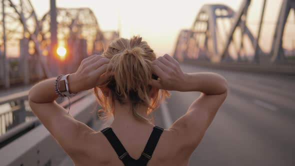 a Fairhaired Girl Straightens Her Hair in a Ponytail and Prepares for a City Morning Run at Dawn on